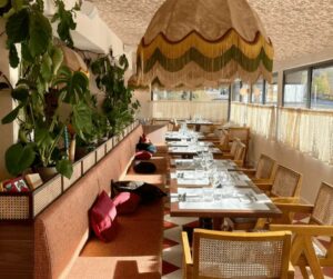 Un salle à manger avec tabourets vintage et étagères recyclées