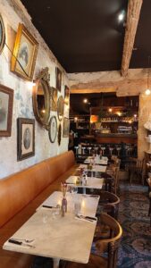 Intérieur de restaurant avec chaises bistrot chinées et vaisselle dépareillée vintage Restaurant Au Petit Bistrot