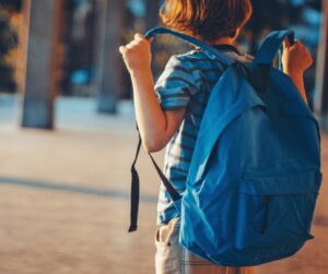 Ecolier avec son cartable sur le dos qui va faire sa rentrée scolaire avec des fournitures scolaires de seconde main dans son cartable , fournitures scolaires zero déchet